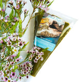 A bulk bag of fresh henna paste next to small purple flowers