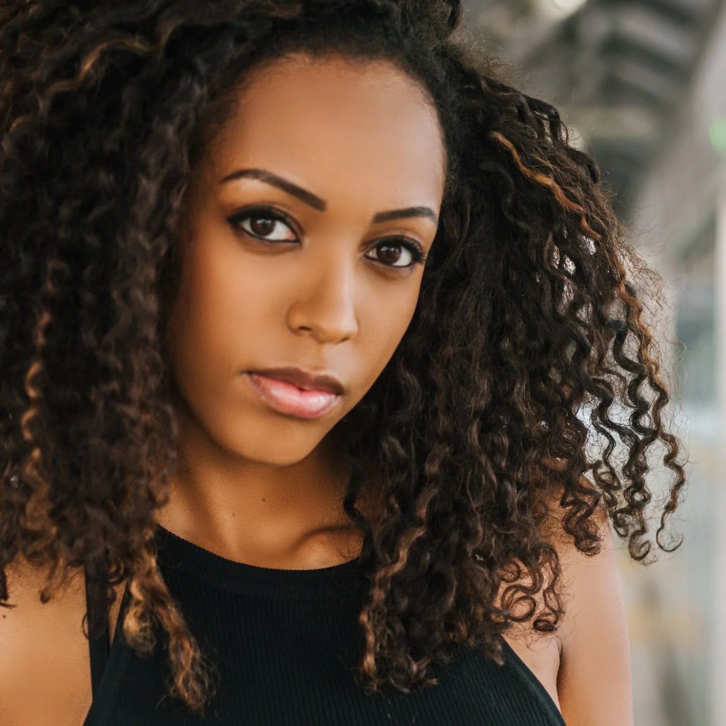 A Black woman with beautiful natural curls dyed with indigo