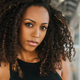 A Black woman with beautiful natural curls dyed with indigo