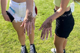 Two teenage girls with simple festival henna designs on their hands