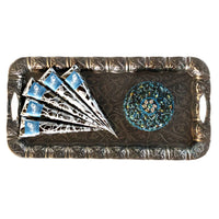 An intricate silver decorative tray holding fresh henna cones