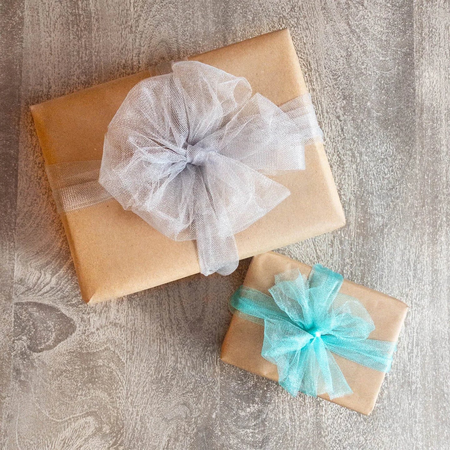 Two boxes wrapped in brown kraft paper with colorful ribbons