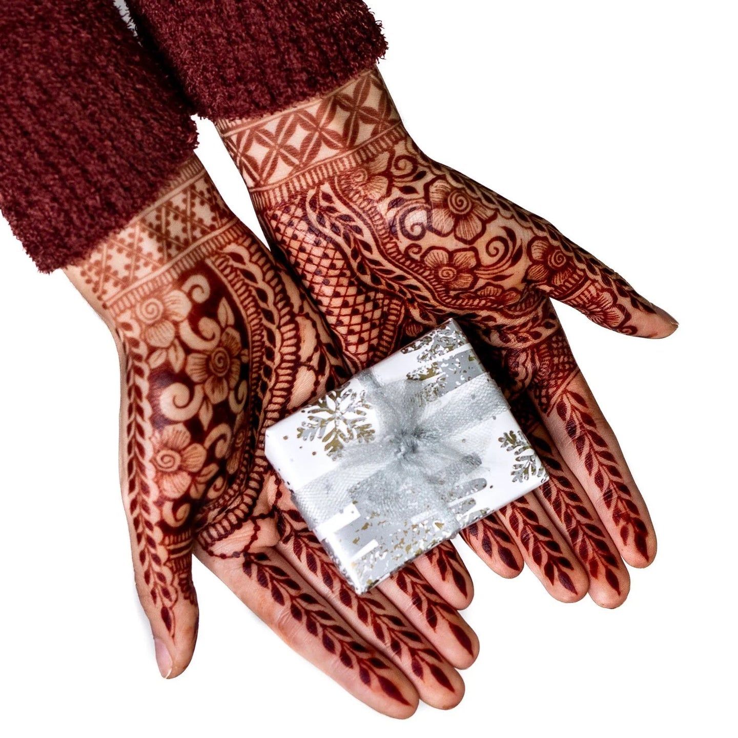 Henna stained hands holding a gift box