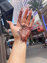 A hand with a dark henna stain held up to the Las Vegas background