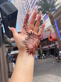 A hand with a dark henna stain held up to the Las Vegas background