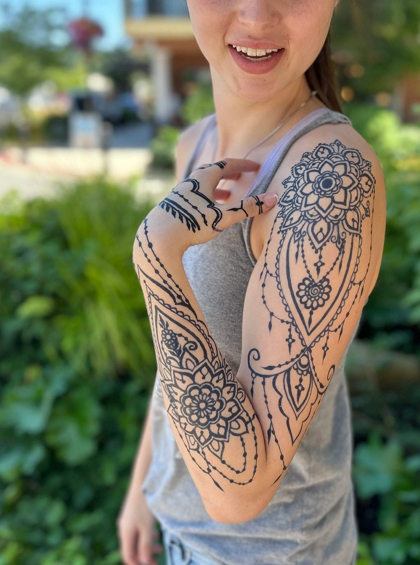 A woman with a full sleeve jagua temporary tattoo on her arm