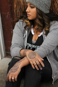 A Black woman with dark jagua stains on both of her hands