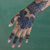 A Black woman's hand with a dark jagua stain