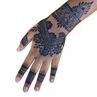 A Black woman's hand with a dark jagua stain