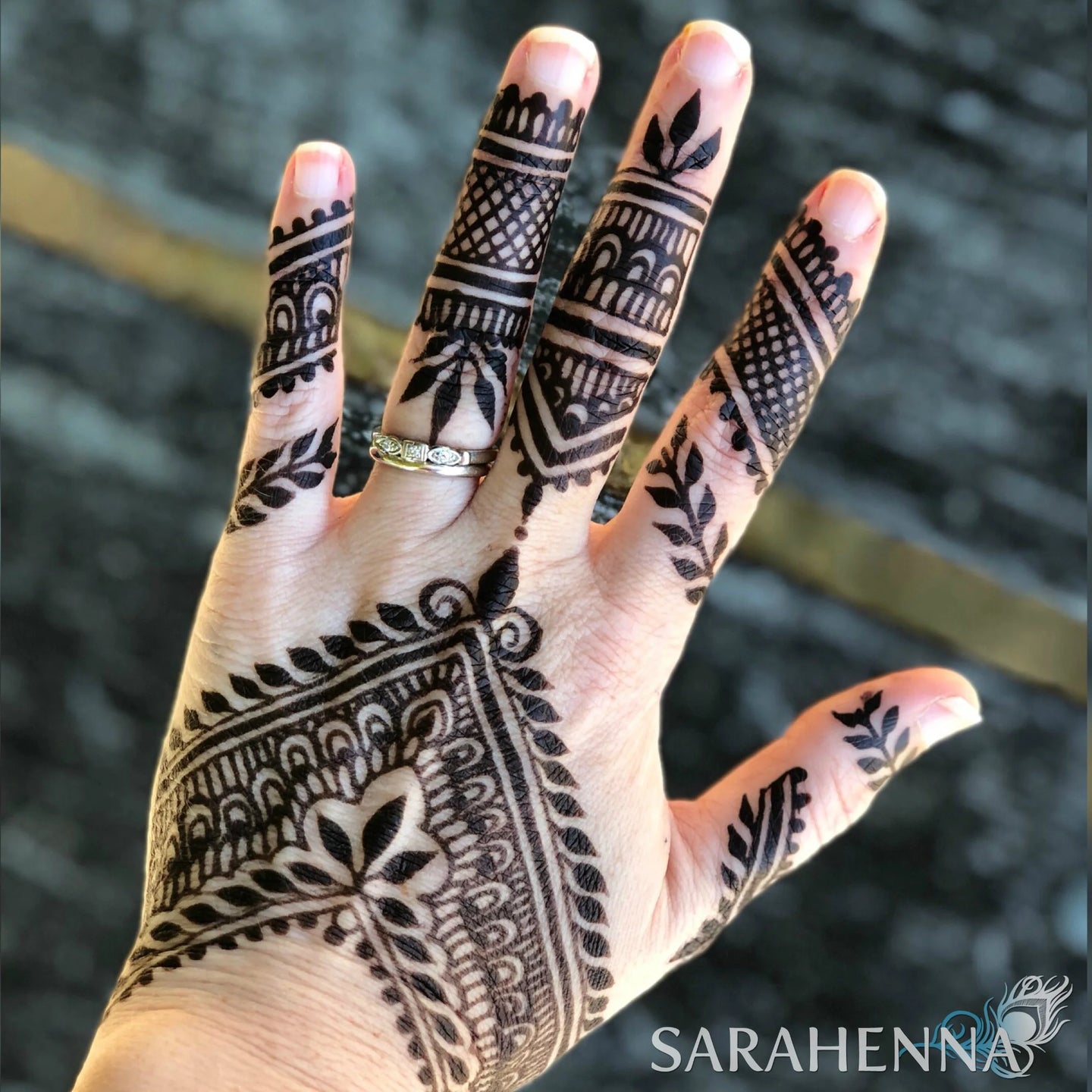 A woman's hand with a dark jagua henna stain