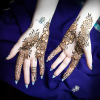 Intricate henna design on the palms of hands that have been sprayed with finishing spray