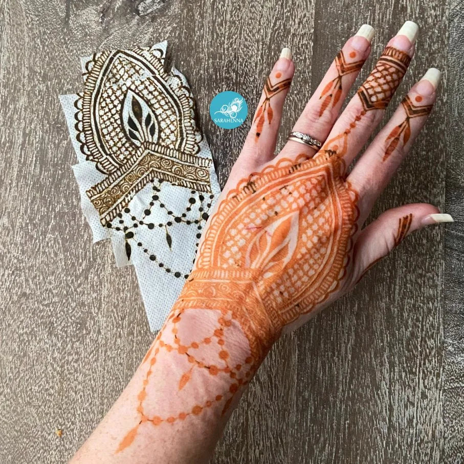 A hand with a fresh henna stain next to Mefix medical tape with dried henna stuck to it