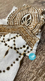 A piece of Mefix medical tape with a dried henna design stuck to it