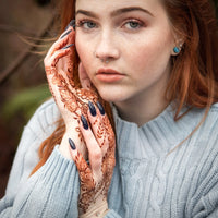 A rich red henna stain on the hand of a red haired young woman