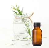 A glass bottle of tea tree essential oil