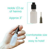 Small bottle for henna with a fine tip held in a hand, labeled with capacity and size information.