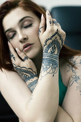 An ultra dark blue black jagua design on a woman's hands